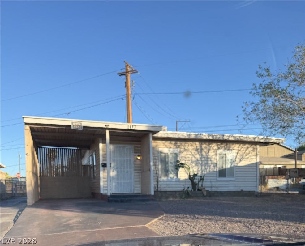 107 W Victory Road, Henderson, NV 89015 Simple single-level home features a covered carport and paved driveway under clear blue skies.