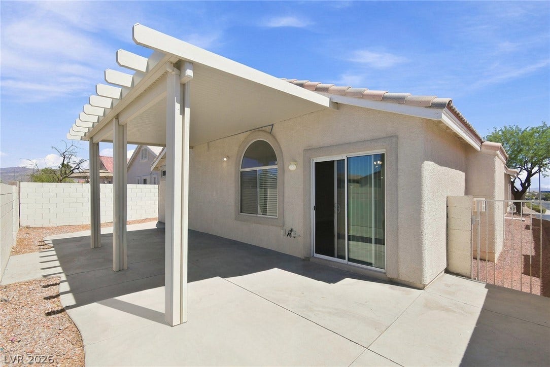 6059 Camden Cove Street, North Las Vegas, NV 89081 An inviting covered patio features clean concrete flooring beneath a solid stucco exterior.