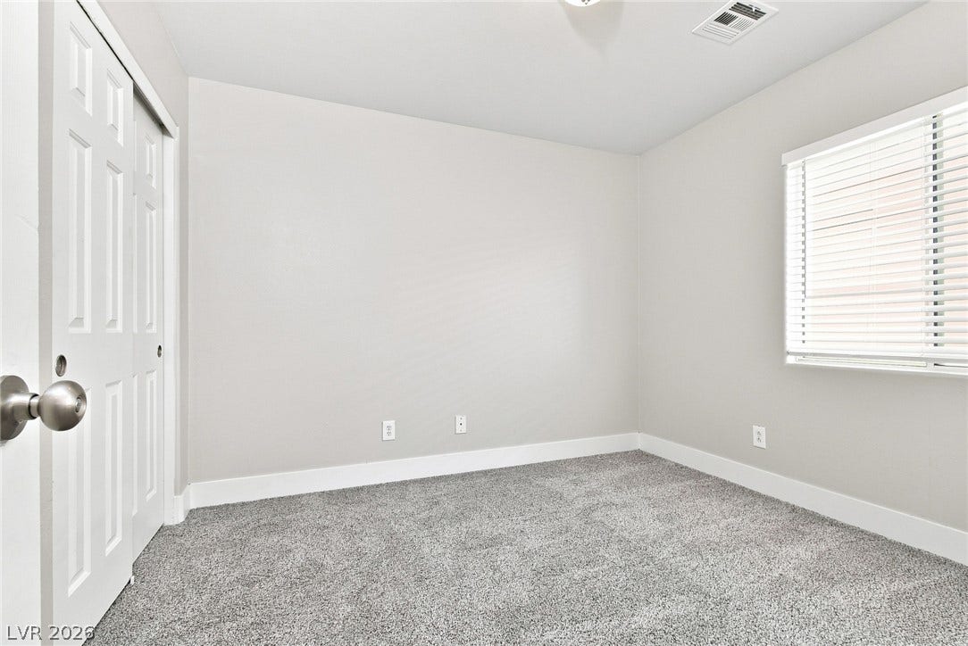 6059 Camden Cove Street, North Las Vegas, NV 89081 Plush carpeting and a large window create a comfortable, inviting atmosphere.