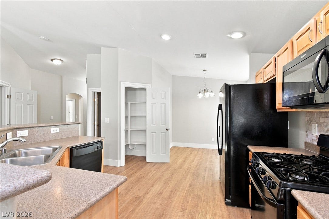 6059 Camden Cove Street, North Las Vegas, NV 89081 Smooth wood-style flooring complements the functional workspace design and adjacent walk-in pantry.