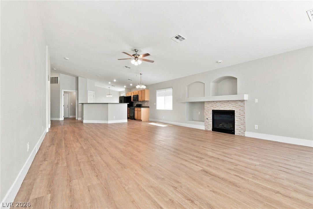 6059 Camden Cove Street, North Las Vegas, NV 89081 An inviting fireplace serves as the focal point in this expansive, wood-floored great room.