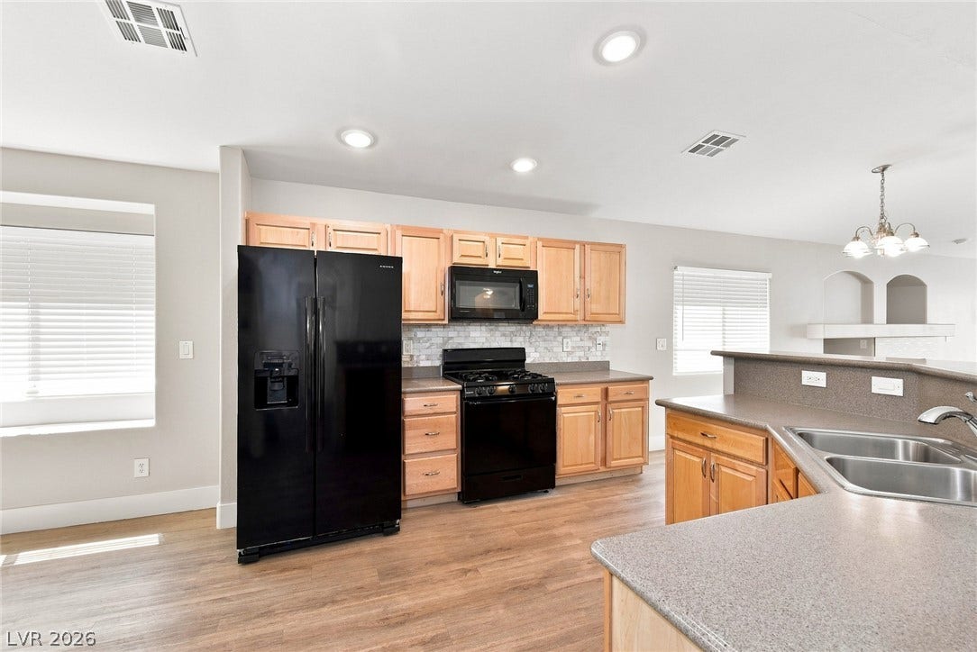 6059 Camden Cove Street, North Las Vegas, NV 89081 Warm wood cabinetry and durable hard surface flooring define this open, functional culinary space.