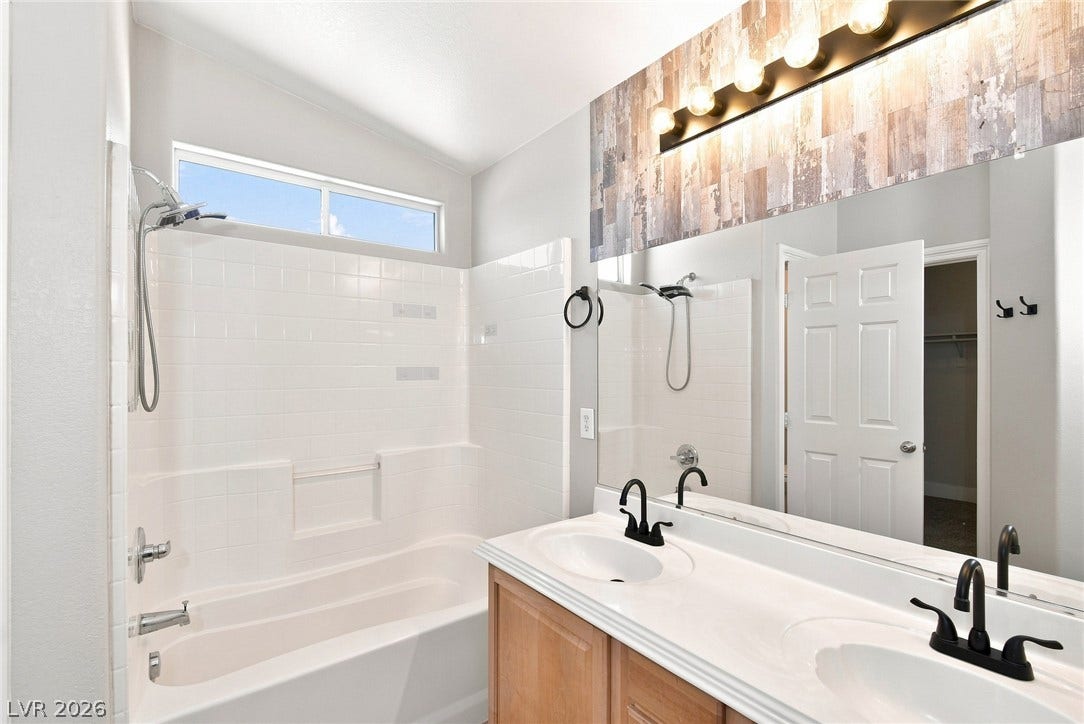 6059 Camden Cove Street, North Las Vegas, NV 89081 A vaulted ceiling and clerestory window enhance this bathroom featuring a dual sink vanity.