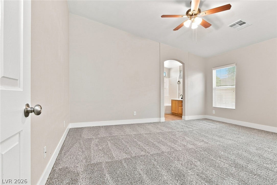 6059 Camden Cove Street, North Las Vegas, NV 89081 An arched doorway connects this plushly carpeted bedroom directly to an adjoining bathroom.