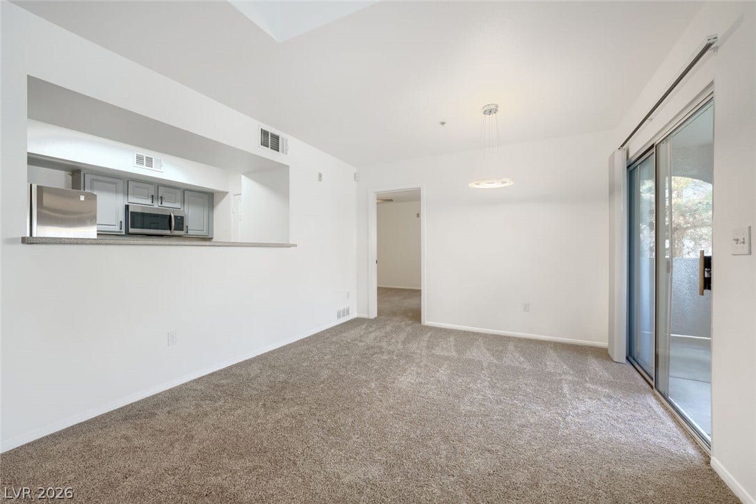 6955 N Durango Drive, #3102, Las Vegas, NV 89149 Spacious, light-filled dining area with new carpet, new paint, open sightlines to the kitchen, and direct access to the balcony.
