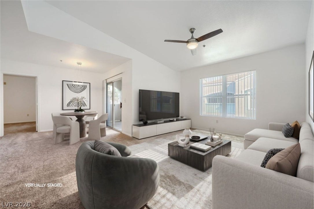 6955 N Durango Drive, #3102, Las Vegas, NV 89149 An open living and dining area features plush new carpeting, new paint, and sliding glass door access to balcony.