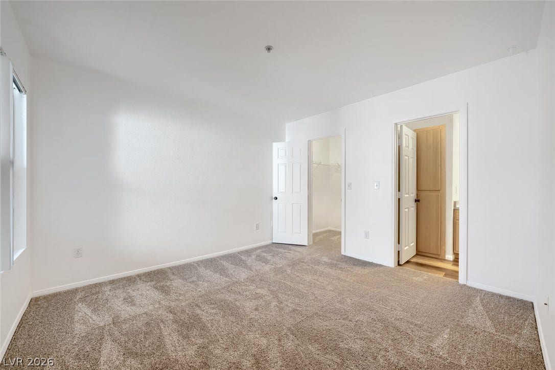 6955 N Durango Drive, #3102, Las Vegas, NV 89149 Primary bedroom with new carpet and fresh paint, featuring an en suite bath and walk-in closet.