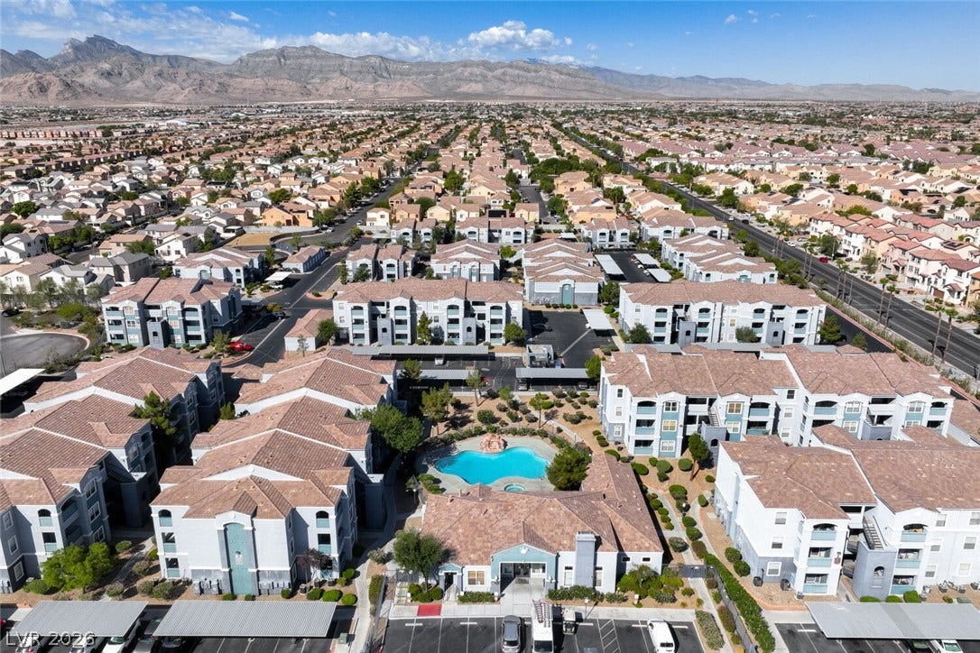 6955 N Durango Drive, #3102, Las Vegas, NV 89149 Aerial view showcasing the west facing mountains, community pool, clubhouse and fitness center, with Red Rock Canyon and Mt. Charleston in the distance.