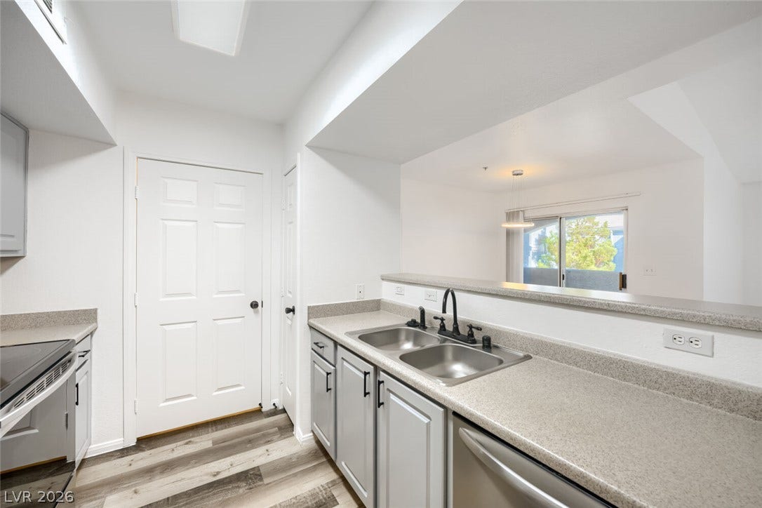 6955 N Durango Drive, #3102, Las Vegas, NV 89149 Bright kitchen with open pass-through overlooking the dining area and balcony, creating an open and connected living space.