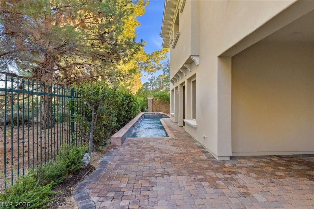 12056 Royal Dolnoch Court, Las Vegas, NV 89141 A long water feature and custom pavers line the side of this elegant exterior.