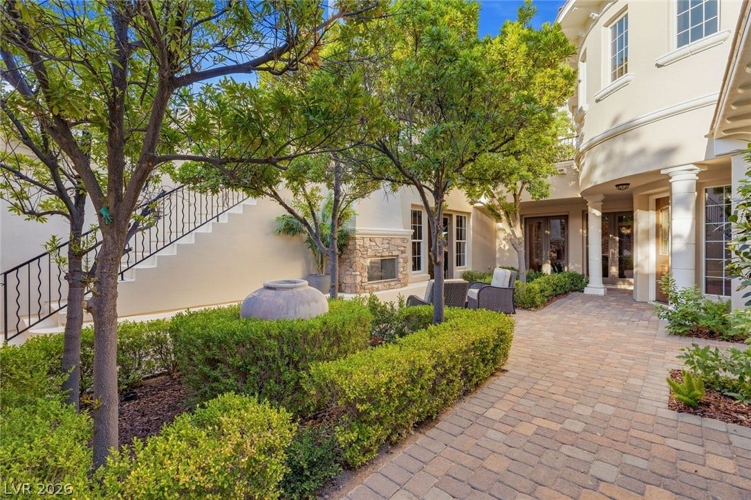 12056 Royal Dolnoch Court, Las Vegas, NV 89141 An inviting stone-paved courtyard is surrounded by mature landscaping and a cozy outdoor fireplace.