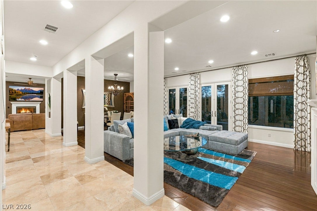 12056 Royal Dolnoch Court, Las Vegas, NV 89141 Polished tile flooring transitions to rich hardwood in this open living space with architectural pillars.