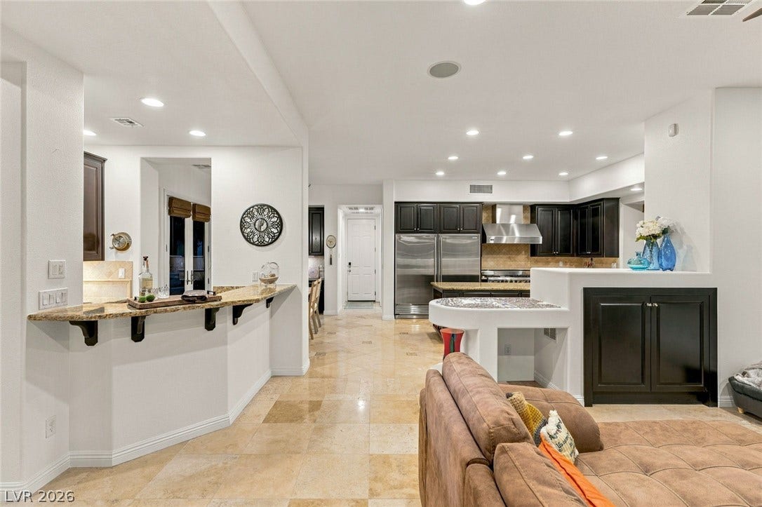 12056 Royal Dolnoch Court, Las Vegas, NV 89141 Polished tile flooring and an open layout seamlessly connect the living areas and kitchen.