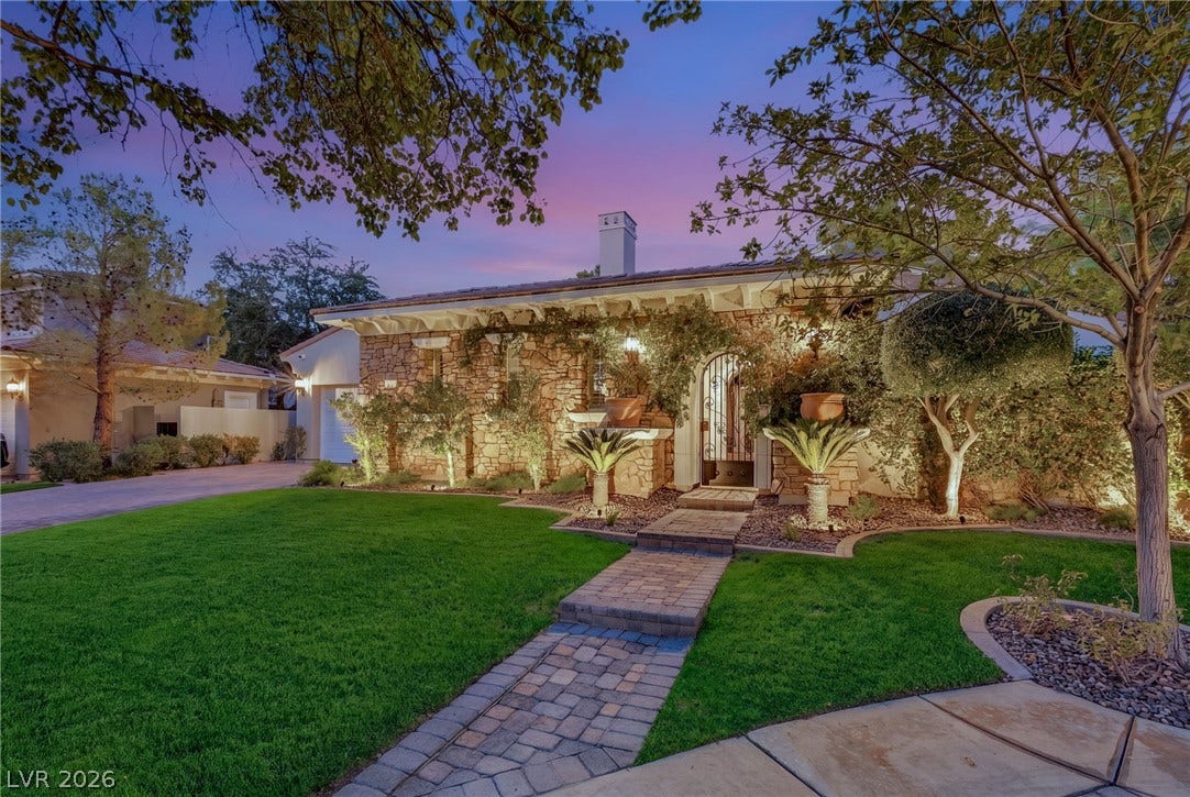 12056 Royal Dolnoch Court, Las Vegas, NV 89141 Mature trees frame a charming stone facade and brick pathway leading to the arched entry.