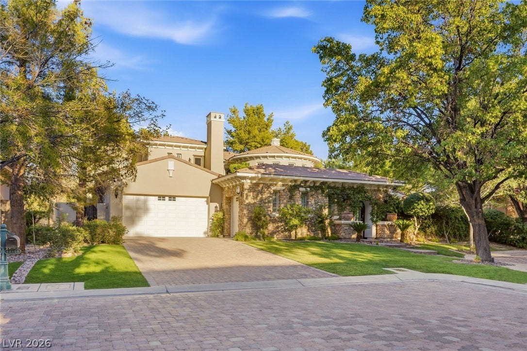 12056 Royal Dolnoch Court, Las Vegas, NV 89141 Mature trees frame a beautifully textured stone facade and brick-paved driveway.