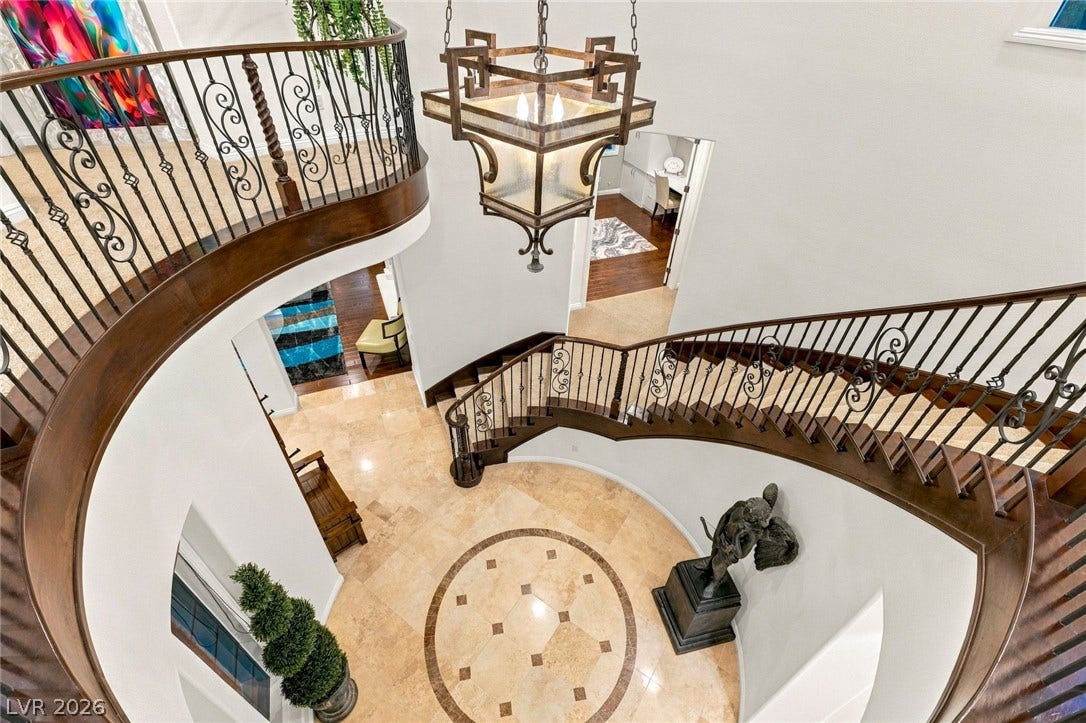 12056 Royal Dolnoch Court, Las Vegas, NV 89141 A sweeping staircase with elegant wrought iron railings encircles the grand tiled entrance foyer.