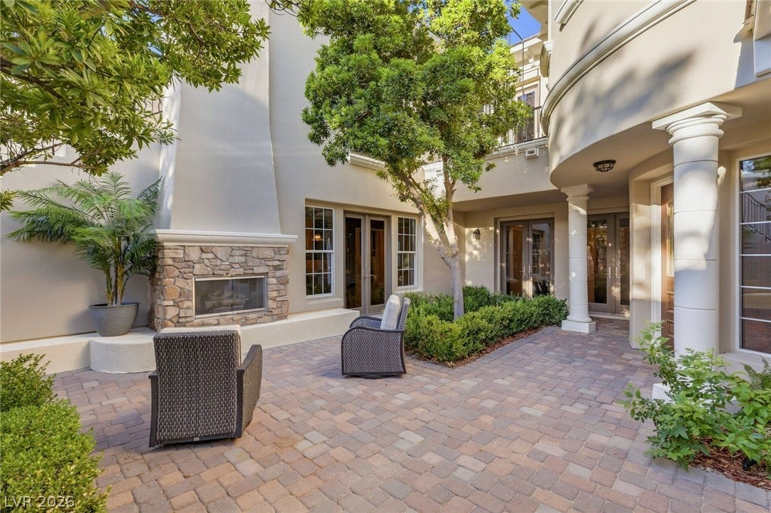 12056 Royal Dolnoch Court, Las Vegas, NV 89141 An inviting stone fireplace anchors this paved courtyard, perfect for relaxed outdoor gatherings.
