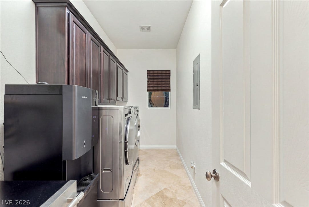 12056 Royal Dolnoch Court, Las Vegas, NV 89141 Rich dark wood upper cabinets elevate this functional utility space with timeless architectural detail.