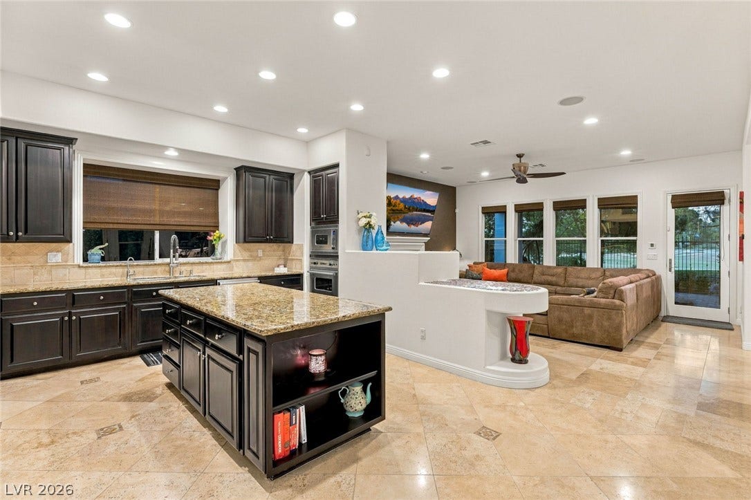 12056 Royal Dolnoch Court, Las Vegas, NV 89141 An open floorplan seamlessly connects the stone-tiled culinary space to the adjoining living area.