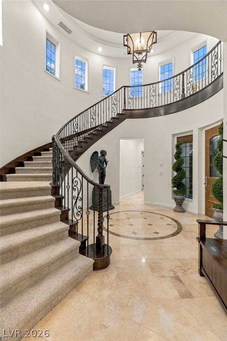 12056 Royal Dolnoch Court, Las Vegas, NV 89141 A curved staircase sweeps upward from the polished tile foyer beneath a soaring dome ceiling.