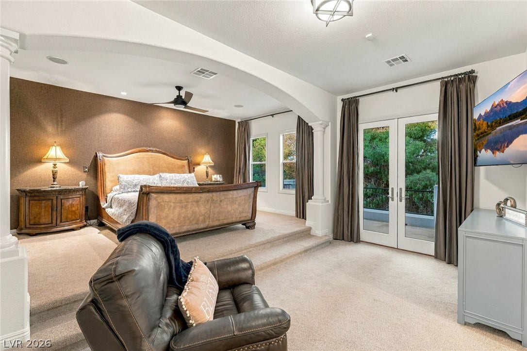 12056 Royal Dolnoch Court, Las Vegas, NV 89141 An arched transition separates the sleeping and lounging areas in this multi-level primary suite.