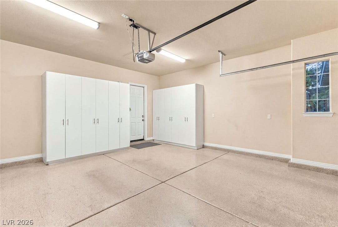 12056 Royal Dolnoch Court, Las Vegas, NV 89141 Ample built-in storage cabinets line the walls of this clean garage with concrete flooring.