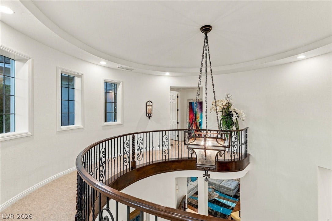 12056 Royal Dolnoch Court, Las Vegas, NV 89141 A curved upper landing overlooking the lower level features detailed wrought iron railings.