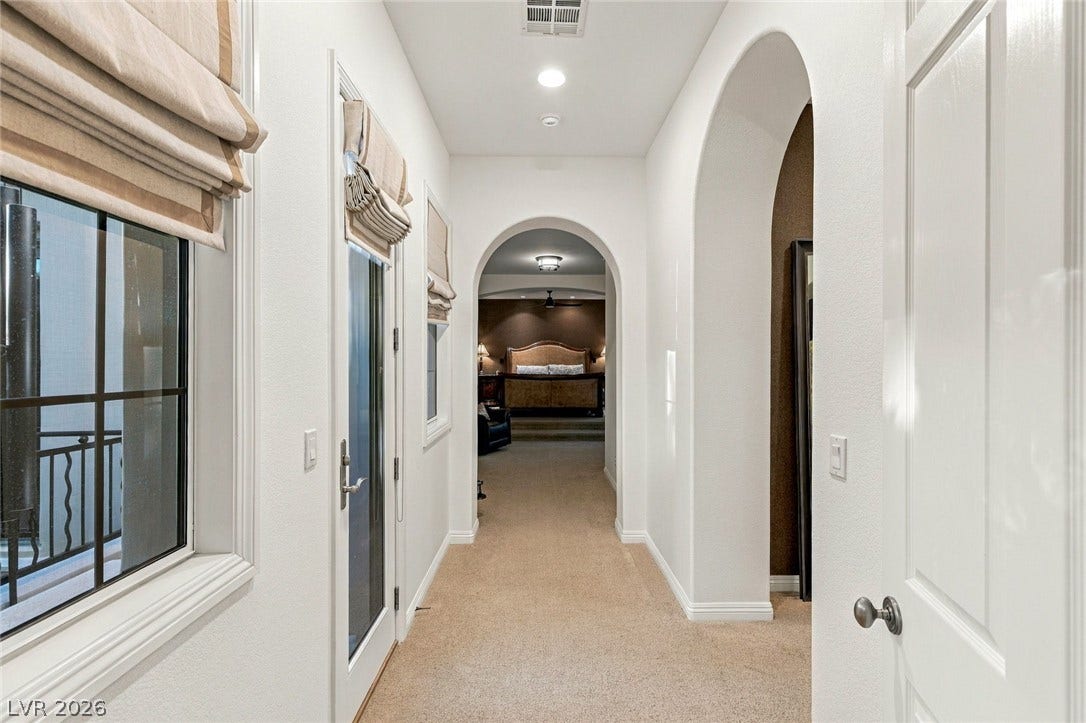 12056 Royal Dolnoch Court, Las Vegas, NV 89141 Elegant arched doorways frame the transition through this classic hallway space.