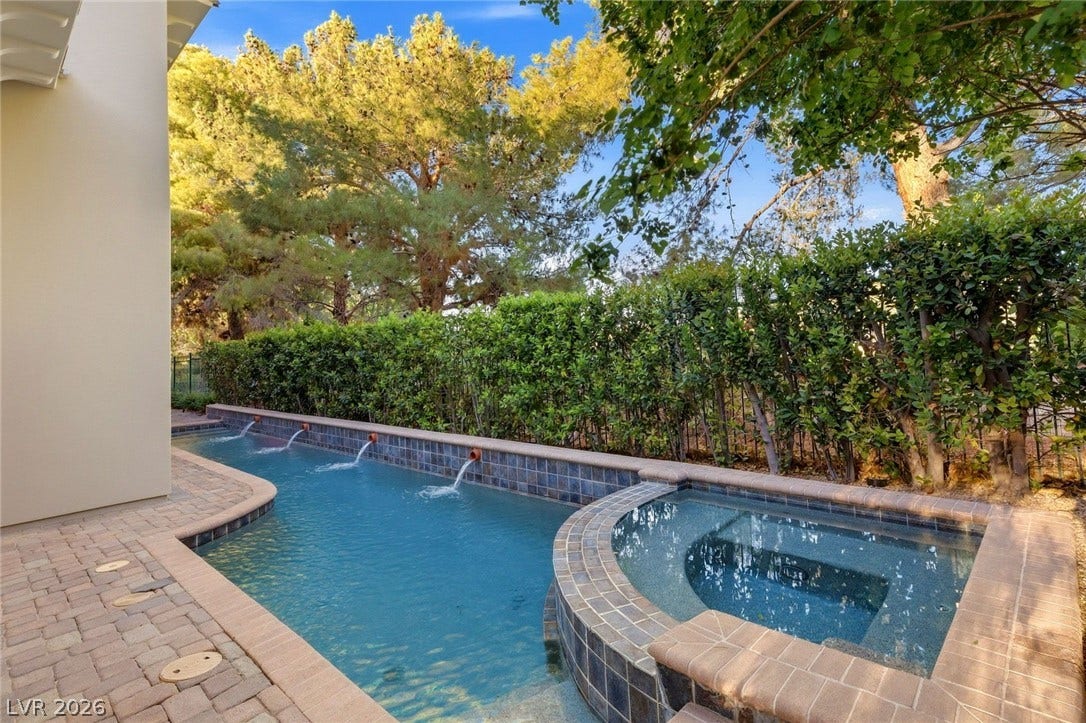 12056 Royal Dolnoch Court, Las Vegas, NV 89141 Mature trees frame a private pool and spa bordered by stone pavers.