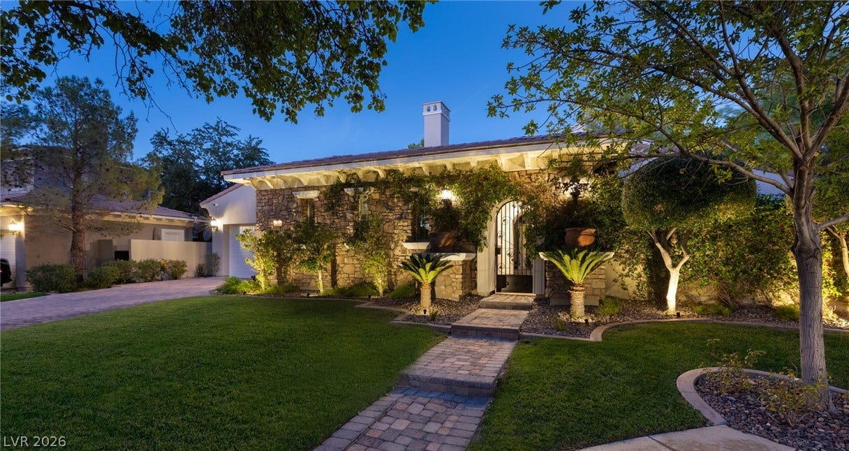 12056 Royal Dolnoch Court, Las Vegas, NV 89141 Lush landscaping and a stone facade frame the inviting entrance of this elegant residence.