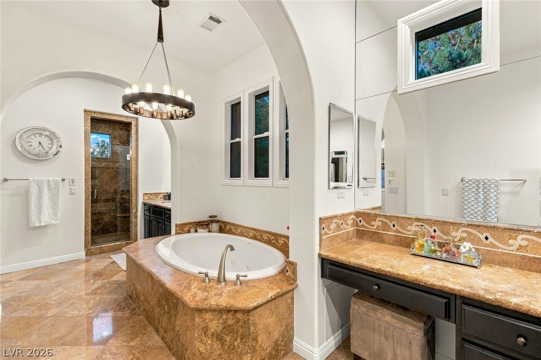 12056 Royal Dolnoch Court, Las Vegas, NV 89141 A deep soaking tub sits under elegant arched entryways on polished tile floors.