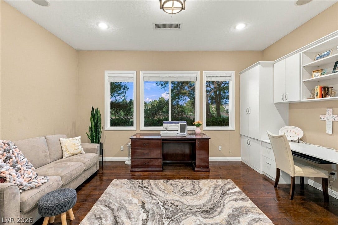 12056 Royal Dolnoch Court, Las Vegas, NV 89141 Rich hardwood flooring complements custom built-in cabinetry and wide windows framing leafy outdoor views.