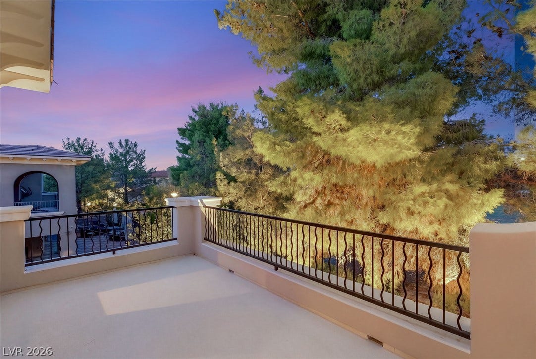 12056 Royal Dolnoch Court, Las Vegas, NV 89141 A spacious elevated balcony looks out toward mature trees and a colorful evening sky.