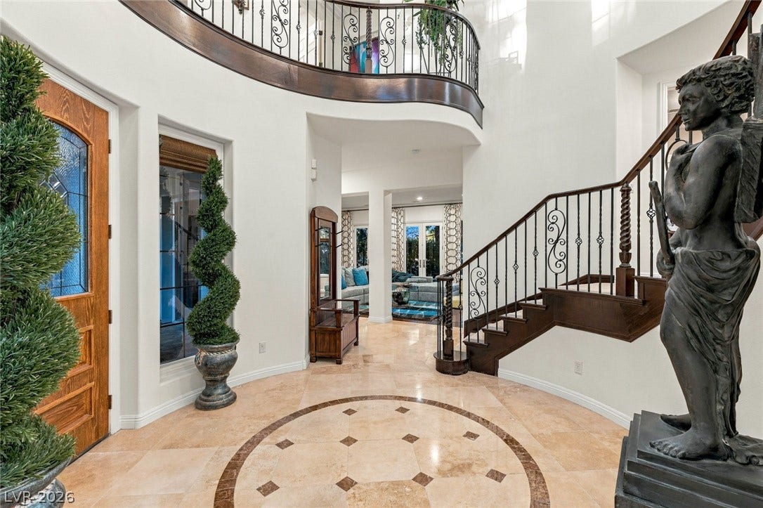 12056 Royal Dolnoch Court, Las Vegas, NV 89141 Polished tile flooring and a sweeping staircase welcome guests into this grand foyer.