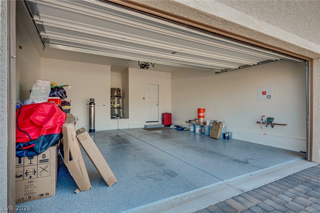 An open garage features textured flooring and seamless access to the interior.