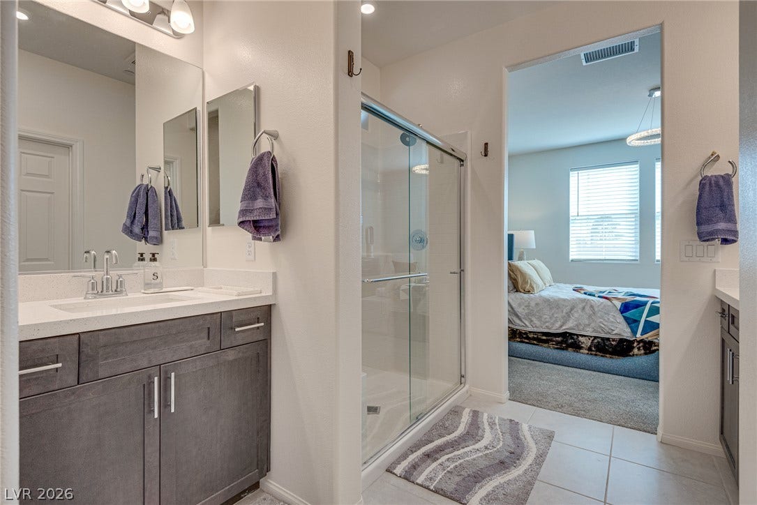 Clean tile flooring and a glass-enclosed shower define this functional, modern bathroom design.