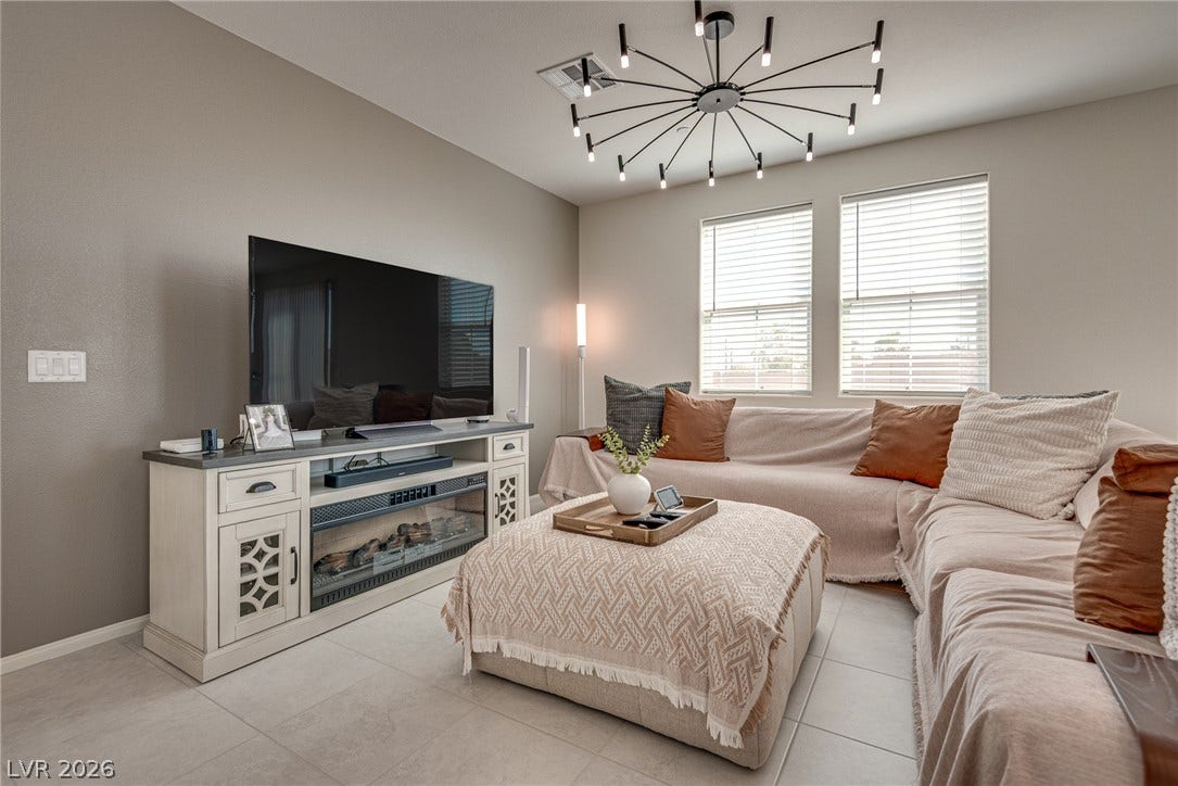 A modern fireplace media console serves as the focal point of this tiled living area.