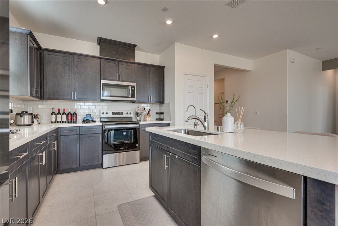 Gleaming stone countertops and dark cabinetry anchor this open culinary space.