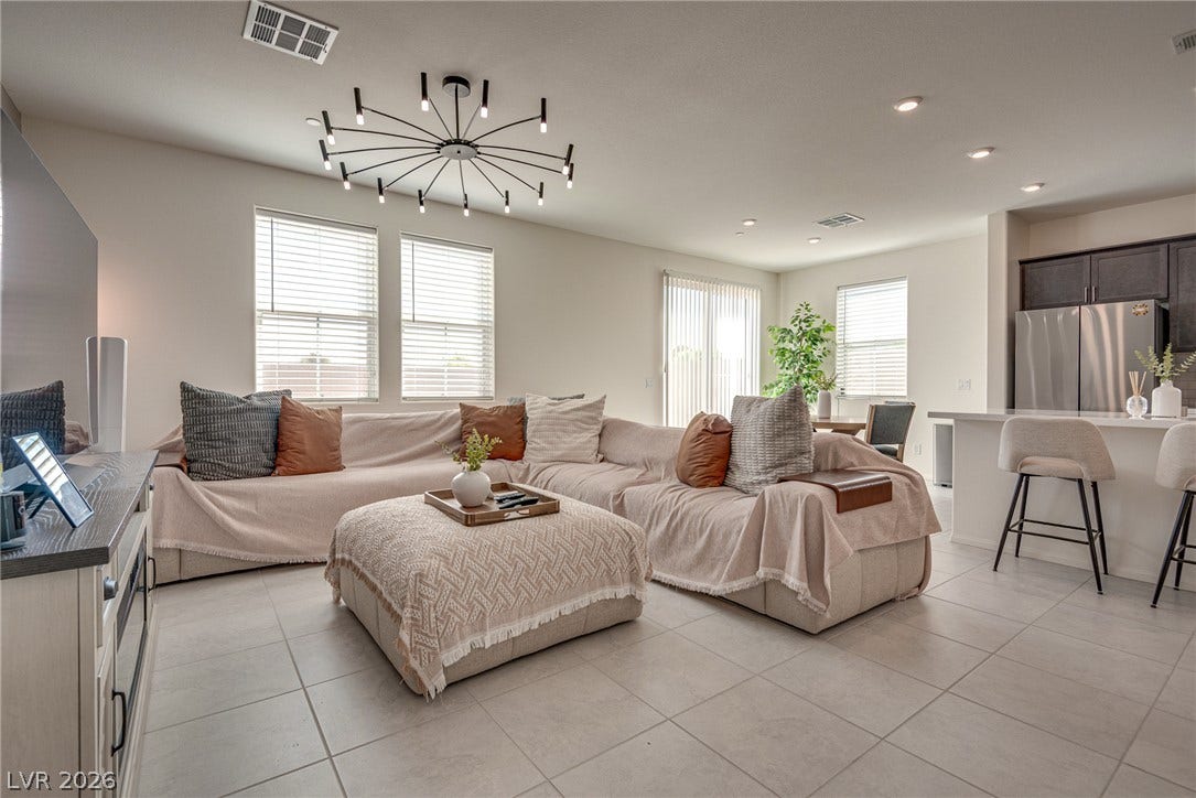 An open floorplan design seamlessly connects the comfortable living area to the nearby kitchen.