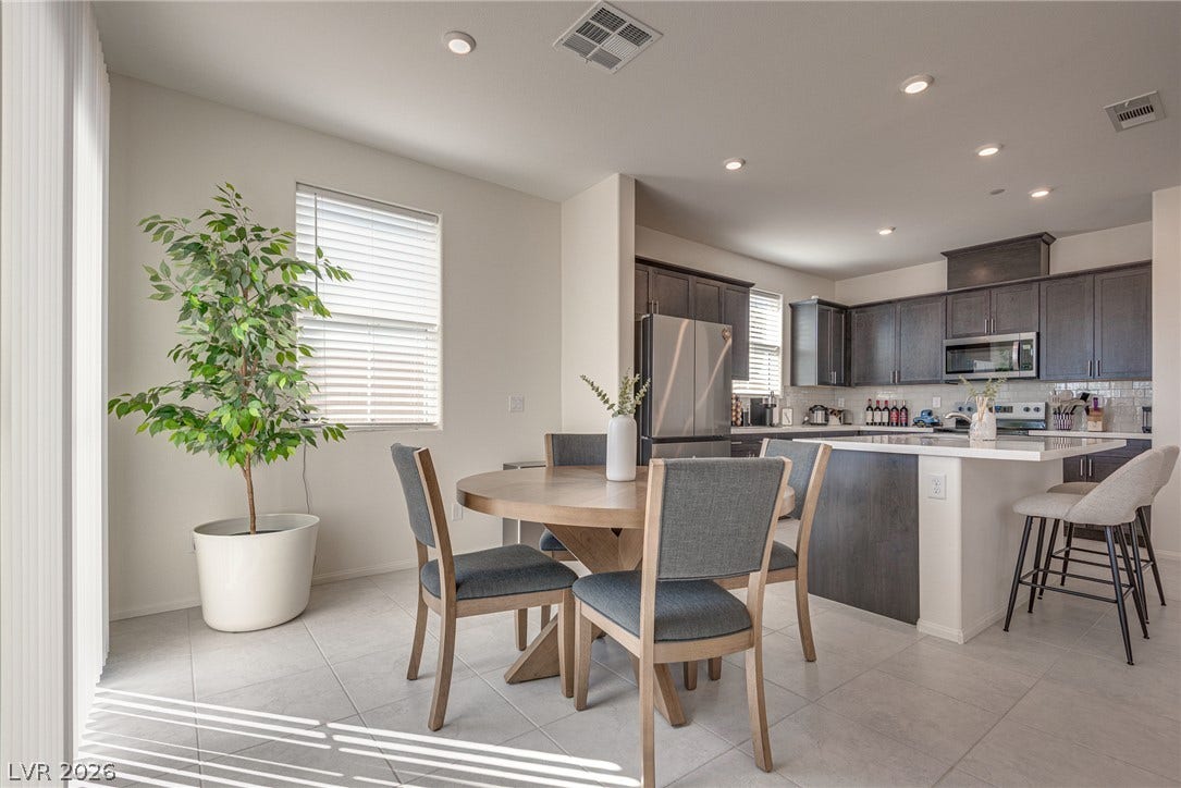 An open floor plan seamlessly connects the tiled dining area to the modern kitchen.