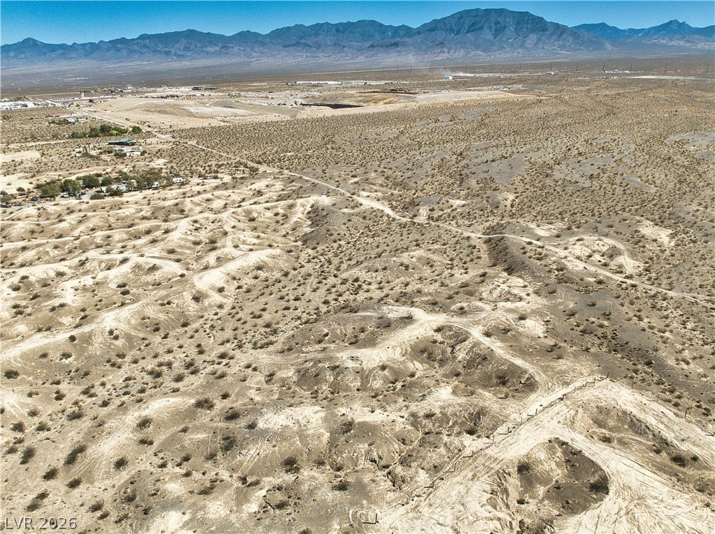 Rugged desert acreage opens up to panoramic mountain vistas under clear blue skies.