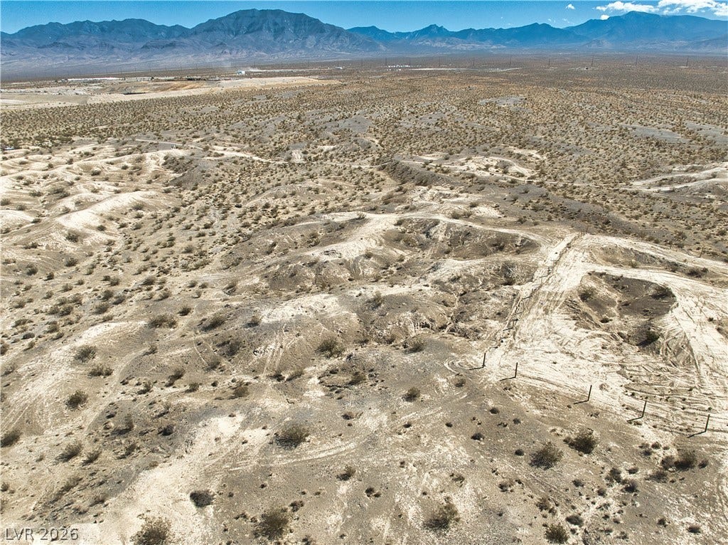 Dramatic mountain vistas frame this expansive desert terrain under a clear blue sky.