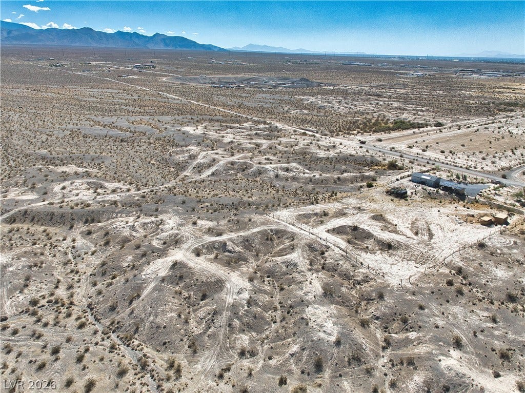 An aerial perspective captures the vast, rugged desert acreage and distant mountain silhouettes.