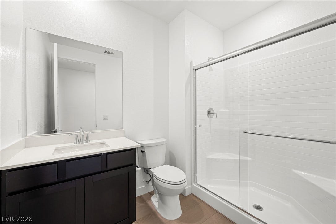 11823 Mimicking Song Lane, Las Vegas, NV 89138 A contemporary vanity with stone counters stands alongside a spacious walk-in shower.