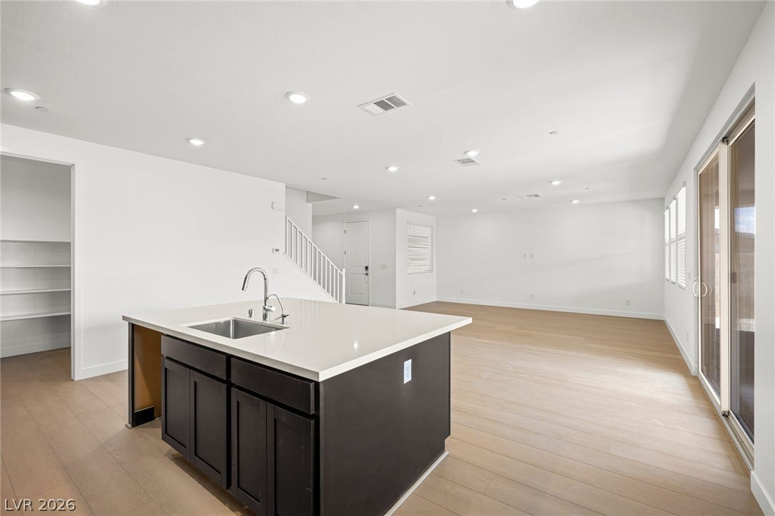 11823 Mimicking Song Lane, Las Vegas, NV 89138 Smooth wood floors flow seamlessly through this open layout featuring a central prep island.