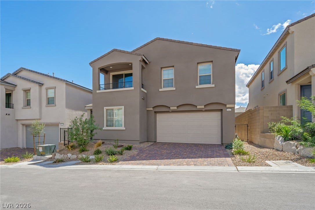 11823 Mimicking Song Lane, Las Vegas, NV 89138 A paved driveway leads to the integrated garage of this modern multi-level stucco home.