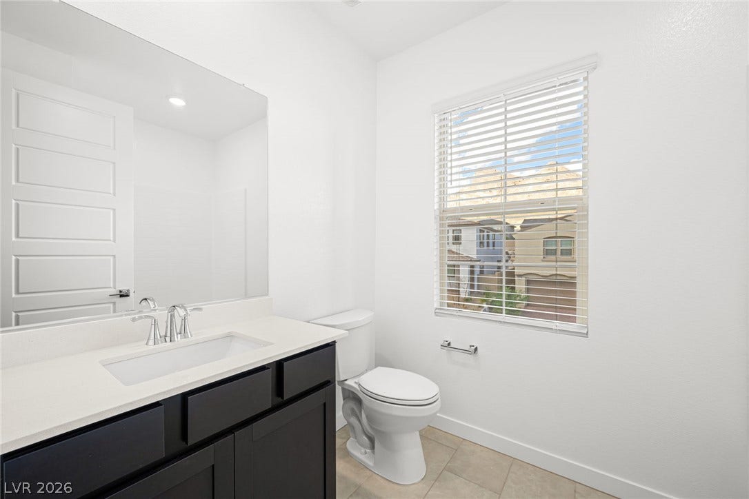11823 Mimicking Song Lane, Las Vegas, NV 89138 Clean lines and stone counters define this modern bathroom with tile flooring.