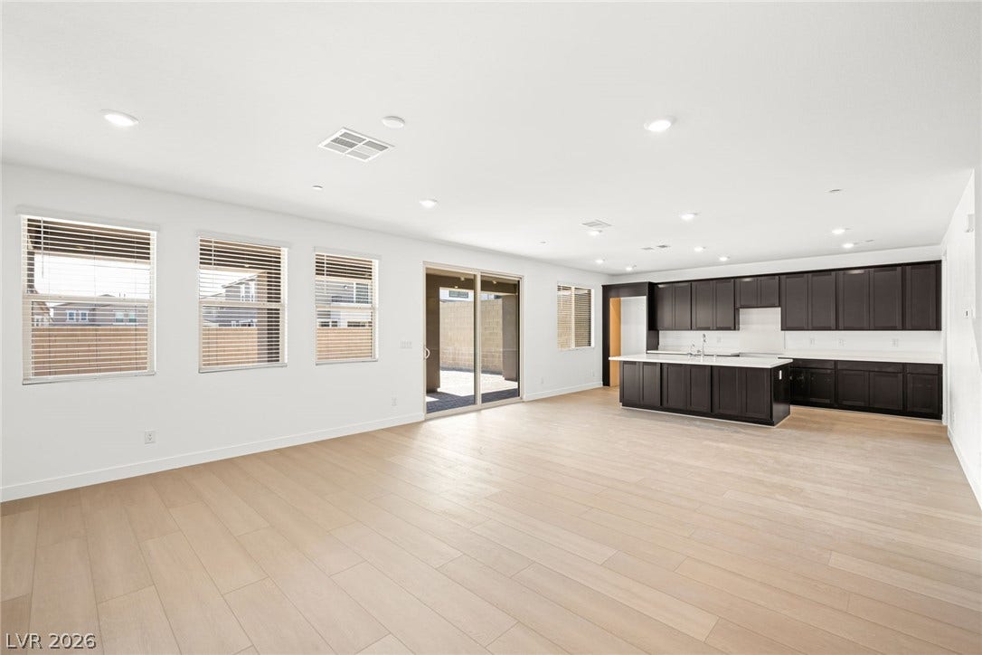 11823 Mimicking Song Lane, Las Vegas, NV 89138 Clean lines and light flooring define this expansive open-concept living area and kitchen.