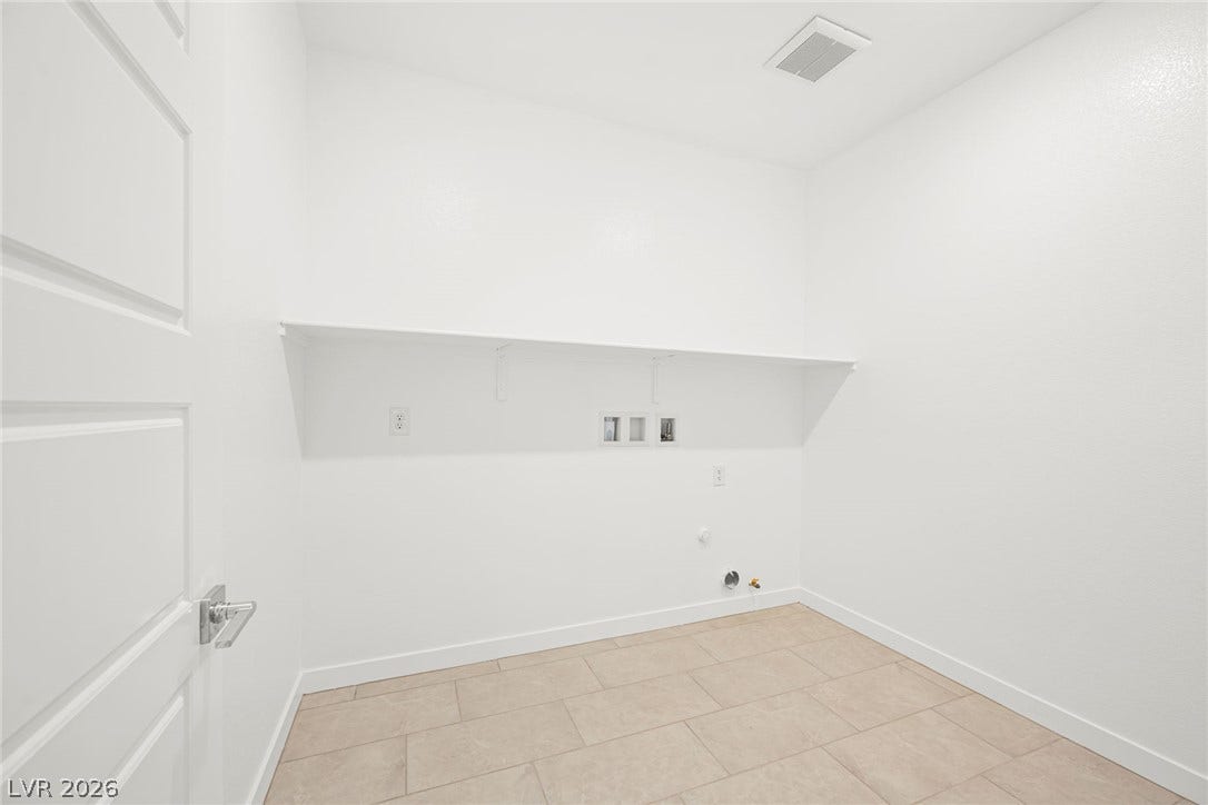 11823 Mimicking Song Lane, Las Vegas, NV 89138 A functional laundry area awaits customizable setup with convenient overhead shelving and durable tile flooring.