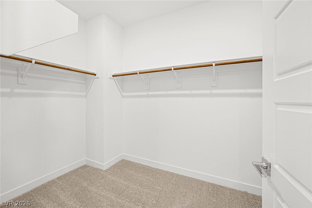 11823 Mimicking Song Lane, Las Vegas, NV 89138 Ample hanging rods and soft carpeting define this functional walk-in closet space.